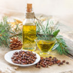 Cedar Oil. Bottles With Cedar Oil And Pine Nuts On The Table.
