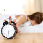 Sleepy Young Woman Trying Kill Alarm Clock