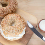 Bagel Sesame With Spread Cream Cheese Close-up On A Wooden Cut B
