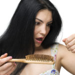 Woman Losing Hair On Hairbrush