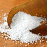 Coarse grained salt on a wooden scoop