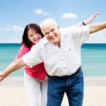 Portrait Of A Happy Senior Couple Having Fun At Beach