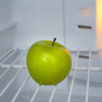 Green apple in an empty fridge
