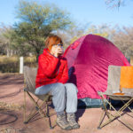 Woman Drinking Hot Coffee Mug While Relaxing In Camping Site. Te