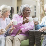 Multiracial senior friends outdoors drinking coffee